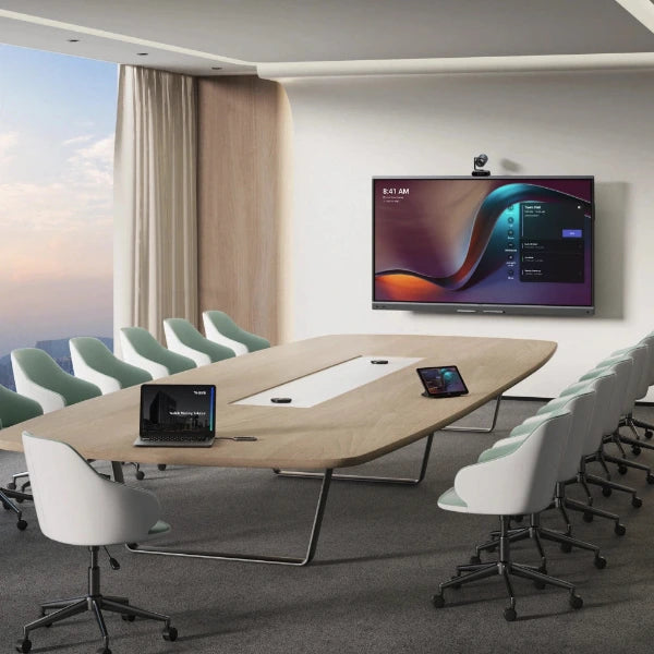 Modern conference room with a large oval table, chairs, and a yealink mb86pro wall-mounted display.